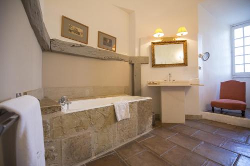 a bathroom with a bath tub and a sink at Château de Mercuès in Mercuès