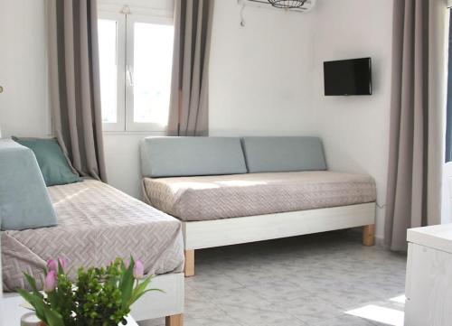 a room with a couch and a bed and a window at Sunny Apt at Regina Apartments in Zakynthos Town