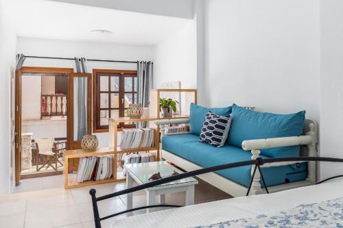 a living room with a blue couch and a table at Sokaki Home in Skopelos Town