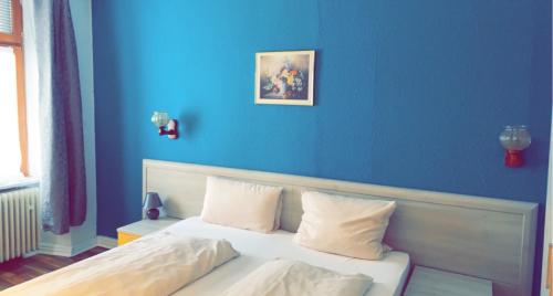 a blue bedroom with a bed with white pillows at Hotel-Restaurant Kastel in Bernkastel-Kues
