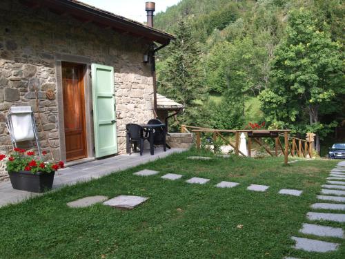 a stone house with a garden and a patio at Il Borgo Dei Celti in Fiumalbo