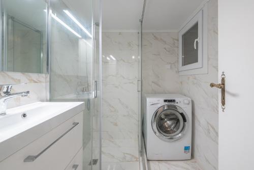 a bathroom with a washing machine in a shower at Victoria Sun Apartments in Athens