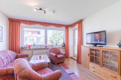 a living room with a couch and a flat screen tv at Vogelsand 325 in Cuxhaven