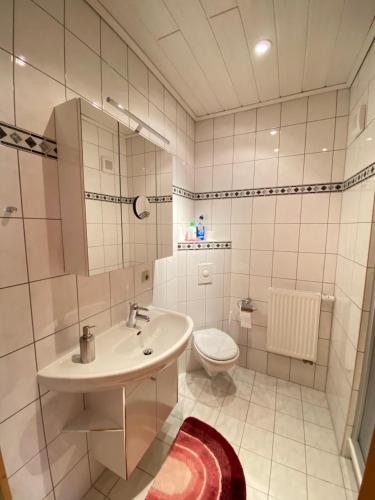 een witte badkamer met een wastafel en een toilet bij Villa Borchert in Wernigerode