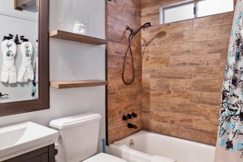 ein Badezimmer mit Badewanne, Toilette und Waschbecken in der Unterkunft Wolf Cub Cabin - 1946 by Big Bear Vacations in Big Bear Lake