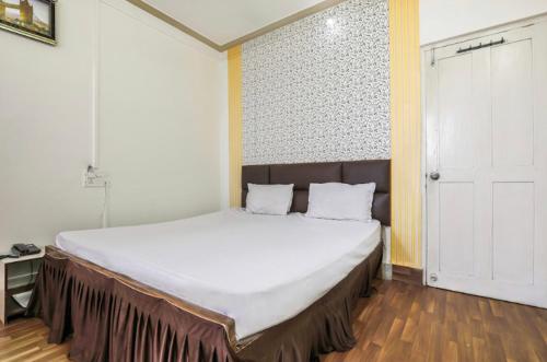 a bedroom with a large bed with white sheets at Hotel Priti International in Mapusa