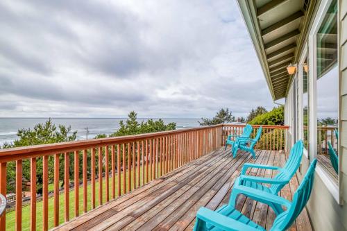 a porch with two blue chairs and the ocean at Hillside House in Lincoln City