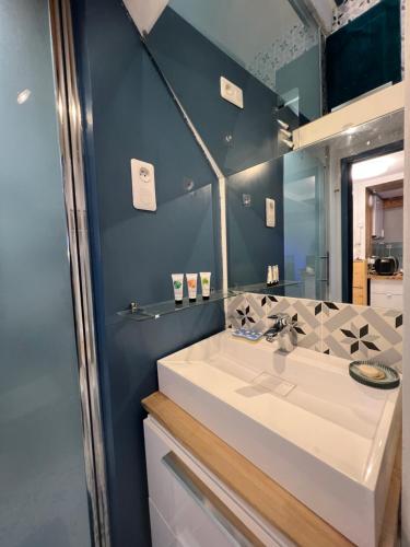 uma casa de banho com um lavatório branco e um espelho. em CosySmartStudio em Montigny-le-Bretonneux