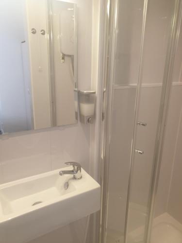 a white bathroom with a sink and a shower at Langroyd Hotel in Blackpool
