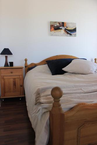 a bedroom with a wooden bed and a night stand at Lakeview Houses Sweden - Red House in Svärdsjö