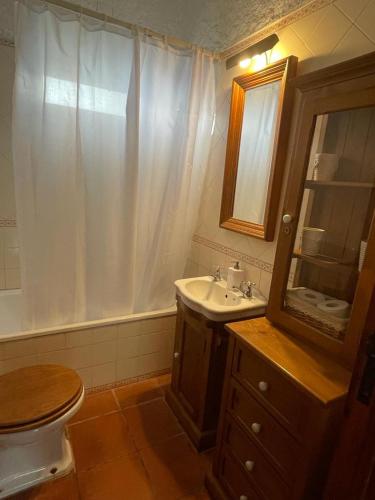 a bathroom with a toilet and a sink and a mirror at 4Sea House in Porto Covo