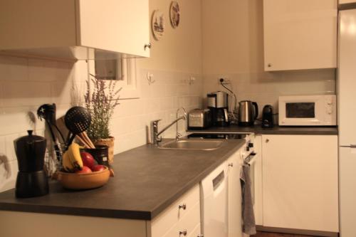 a kitchen with white cabinets and a counter top with a sink at Lakeview Houses Sweden - Red House in Svärdsjö