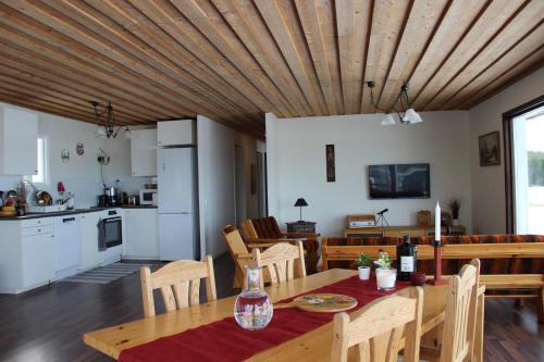 a kitchen and dining room with a wooden ceiling at Lakeview Houses Sweden - Red House in Svärdsjö