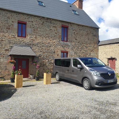 a silver van parked in front of a brick building at Chambres de Villée in Saint-Georges-de-Gréhaigne