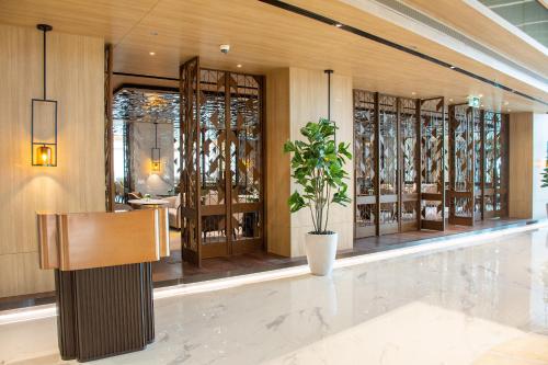 a lobby with a potted plant in a building at Grand Richmond Stylish Convention Hotel in Nonthaburi