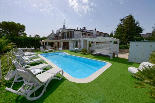 un cortile con piscina, sedie e una casa di In Villa Cielo a Cassano delle Murge