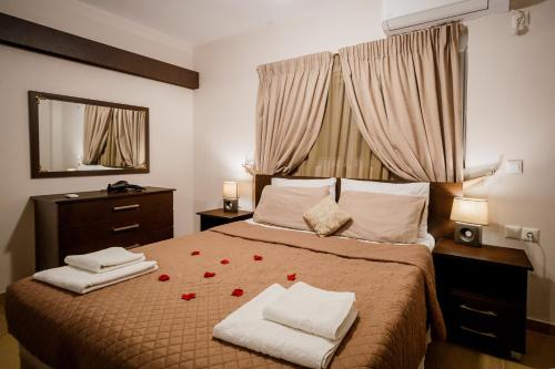 a bedroom with a bed with roses on it at Mirimar Apartments in Alikanas