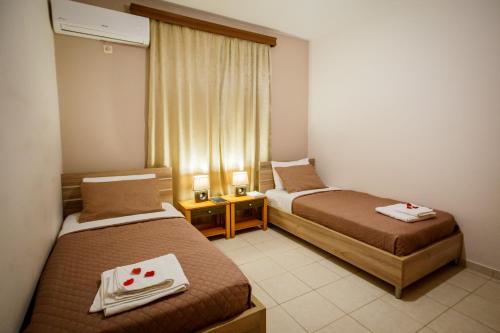 a hotel room with two beds and a window at Mirimar Apartments in Alikanas