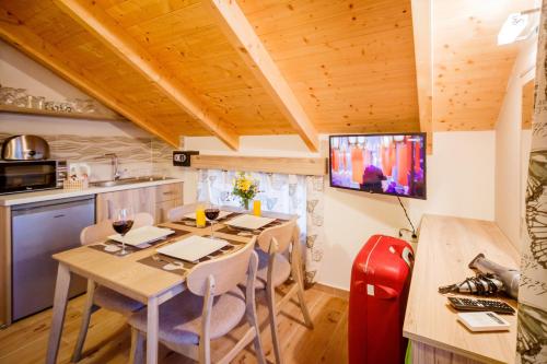 a kitchen and dining room with a table and a television at Mirimar Apartments in Alikanas