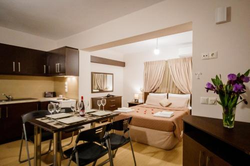 a room with a bed and a table and a kitchen at Mirimar Apartments in Alikanas