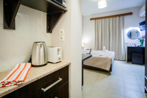 a kitchen with a counter and a room with a bed at Mirimar Apartments in Alikanas