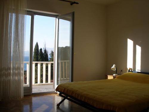 a bedroom with a bed and a large sliding glass door at Apartment Ivan - beautiful sea view in Splitska