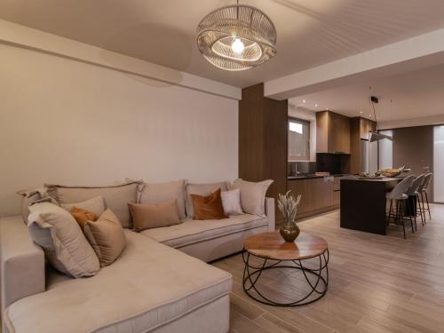 a living room with a white couch and a table at Chrysothemis Villas in Pigadhákia