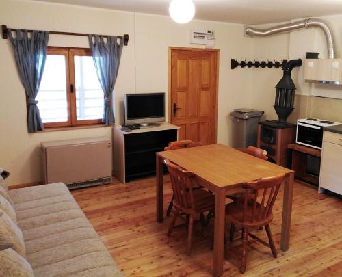 RibnicaにあるKM Apartman Tornik Zlatiborのリビングルーム(木製テーブル付)、キッチン