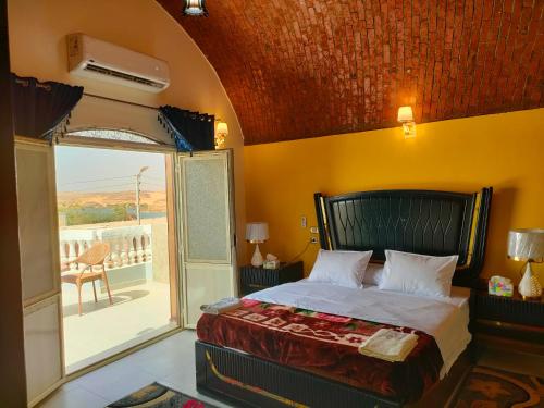 a bedroom with a bed and a balcony at Abu simbel Nubian Guest House in Abu Simbel