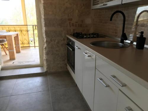 a kitchen with a sink and a counter top at Stone house Chiara Seaview in Funtana