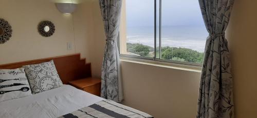 a bedroom with a bed and a large window at 3 BEDROOM-44 Kapenta Bay in Port Shepstone