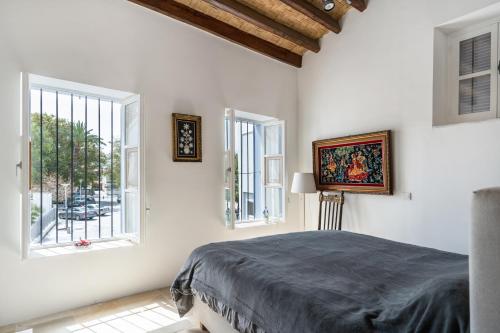 a bedroom with a bed and two windows at To Hani - Kamara Maisonette in Nicosia