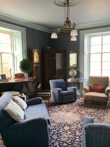 a living room with couches and a grand piano at Kilmorie House in Elgin