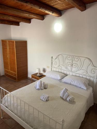 a bedroom with a white bed with towels on it at Terrasini 2000 Case Vacanza in Terrasini
