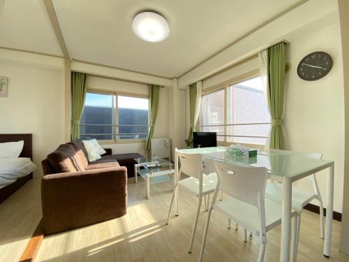 a room with a bed and a table and a couch at Close to Sapporo station & Hokkaido University Hokusei 6F in Sapporo