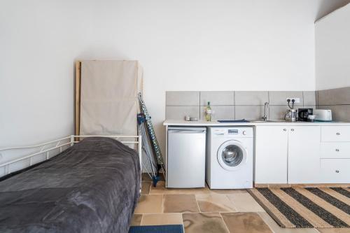 a bedroom with a bed and a washing machine at To Hani - Small Studio in Nicosia