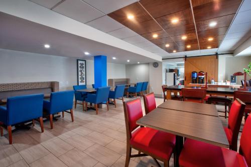 un ristorante con tavoli in legno e sedie blu di Holiday Inn Express Fairfax-Arlington Boulevard, an IHG Hotel a Fairfax