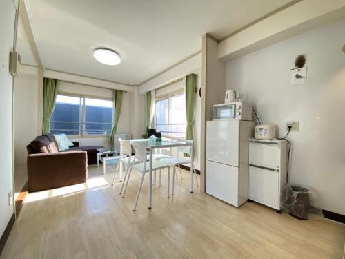 a kitchen and living room with a table and a refrigerator at Close to Sapporo station & Hokkaido University Hokusei 6F in Sapporo