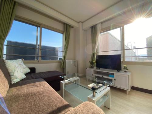 a living room with a couch and a tv at Close to Sapporo station & Hokkaido University Hokusei 6F in Sapporo