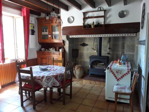 a dining room with a table and a fireplace at La maison du Mas Rando in Saint-Georges-Nigremont