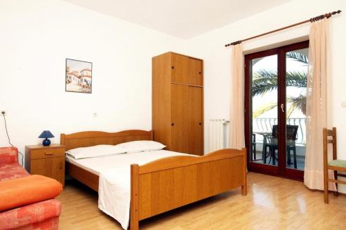 Schlafzimmer mit einem Bett und einer Glasschiebetür in der Unterkunft Apartment Marina - sea view in Trogir