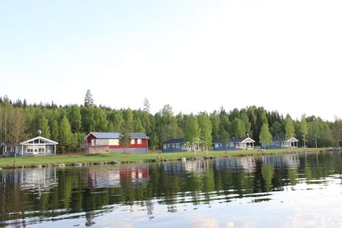 a group of houses on the shore of a lake at Lakeview Houses Sweden - Red House in Svärdsjö