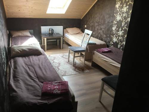 a bedroom with two beds and a table and a chair at Готель Максим Ресторан in Drogovyzhe