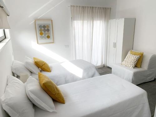 a white room with two beds and a couch at DIANA BEACH HOUSE in Albufeira