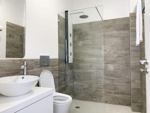 a bathroom with a toilet and a glass shower at DIANA BEACH HOUSE in Albufeira