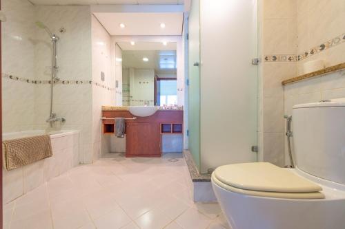 a bathroom with a toilet and a tub and a sink at Elegant and spacious 1bed with 2 balconies in JLT - LAKV in Dubai