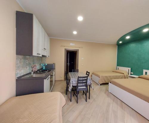 Zimmer mit 2 Betten und einer Küche mit einem Waschbecken in der Unterkunft Parsifal family room in Campofelice di Roccella