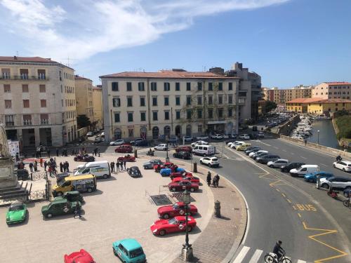 una strada cittadina con auto parcheggiate in un parcheggio di New Maria's House Livorno. Il Cisternone a Livorno