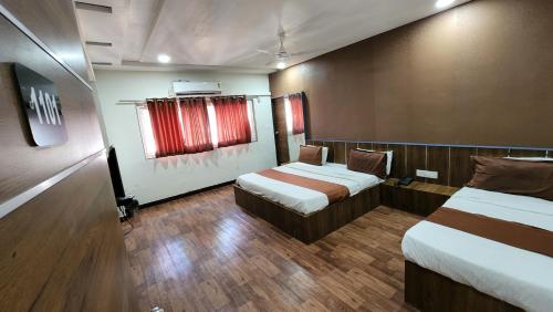 a hotel room with two beds and a window at Hotel Nova Prime in Ahmedabad