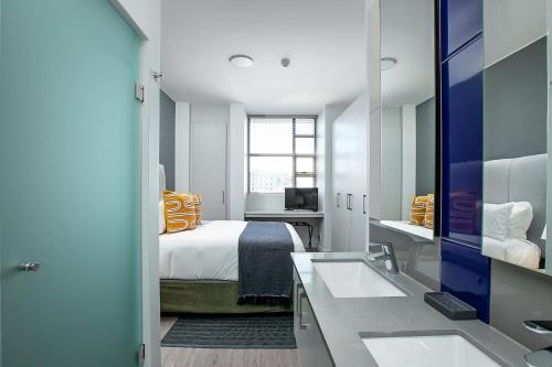 een hotelkamer met een bed en een wastafel bij The Median Serviced Apartment Collection in Johannesburg